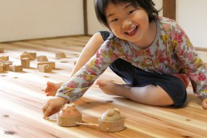 女の子が、赤ちゃんの木のおもちゃで遊んでいる