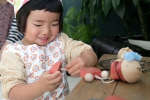 女の子が知育玩具の木のおもちゃで遊んでいる