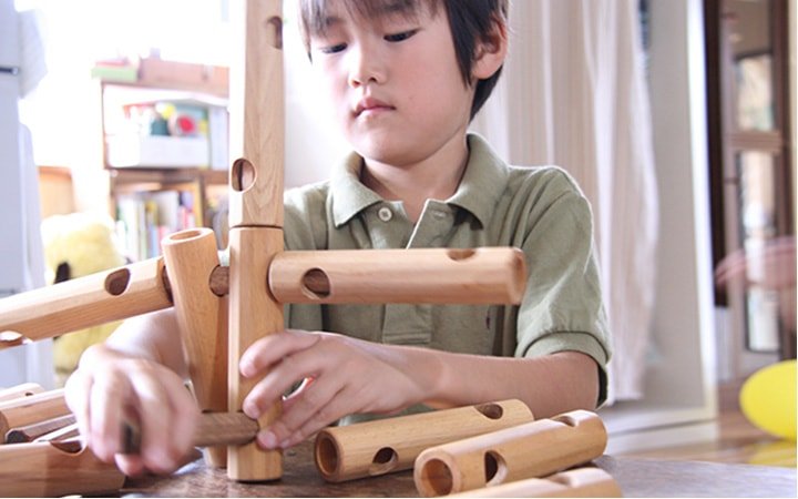 木のおもちゃスレンダーブロック(知育ブロック)を鳴らす子供