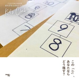 「子どもが手描きで書いた数字や文字を並べた紙の写真。『この“じ”、あなたならどう残す？』というメッセージが添えられている。」 おちびさんのもじとけい
