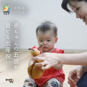 赤ちゃんが木のガラガラQUARTERで遊んでいる様子。天然木のぬくもりを感じられる出産祝いに人気のおもちゃ。