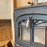 薪ストーブの前に置かれたアイアン扉のアップと温かな工房の雰囲気