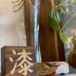 金粉を蒔いた蒔絵の工程で、無垢材の木に「漆」の文字が浮かび上がった一点もの作品