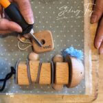 木製のひも通し知育おもちゃで遊ぶ2歳向けバンピーブロックセット。指先を使い集中してひもを通す様子。