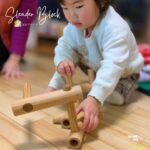 木製の知育ブロック「スレンダーブロック」で遊ぶ子ども。集中して組み立てる様子。